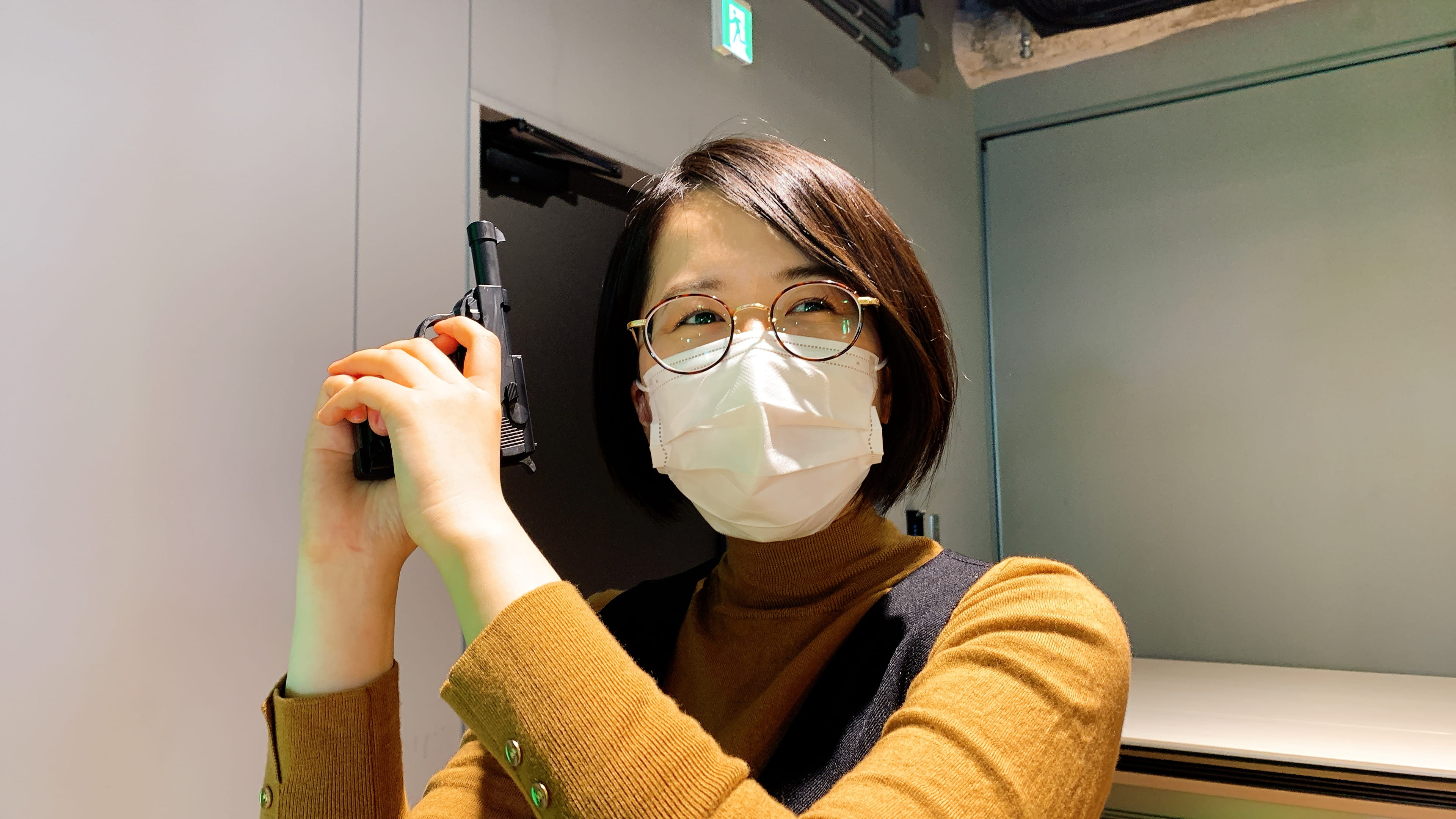 「昨日 100 均で買いました」とピストルを掲げる木全 「マーケポリスとして忖度は取り締まります」というマスクの下は、まんざらでもない